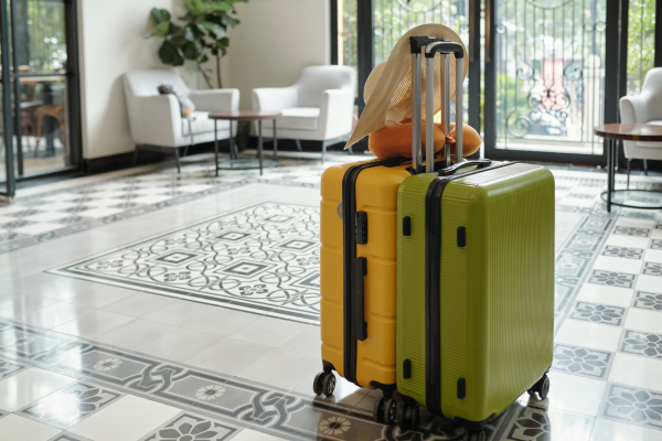 Two rolling suitcases in hotel lobby.