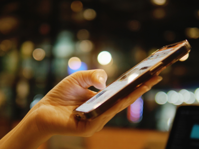 Person's hand scrolling a cell phone